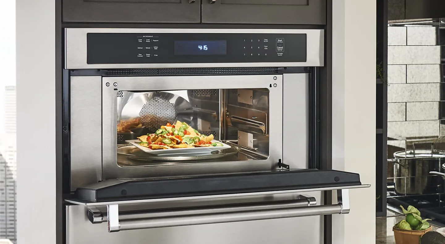 A convection microwave oven pushed too close to a kitchen wall blocking airflow.