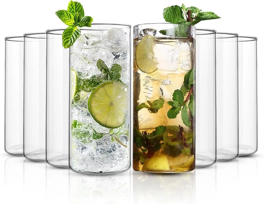 A flat-bottomed stemless tumbler glass holding whiskey poured over ice cubes.